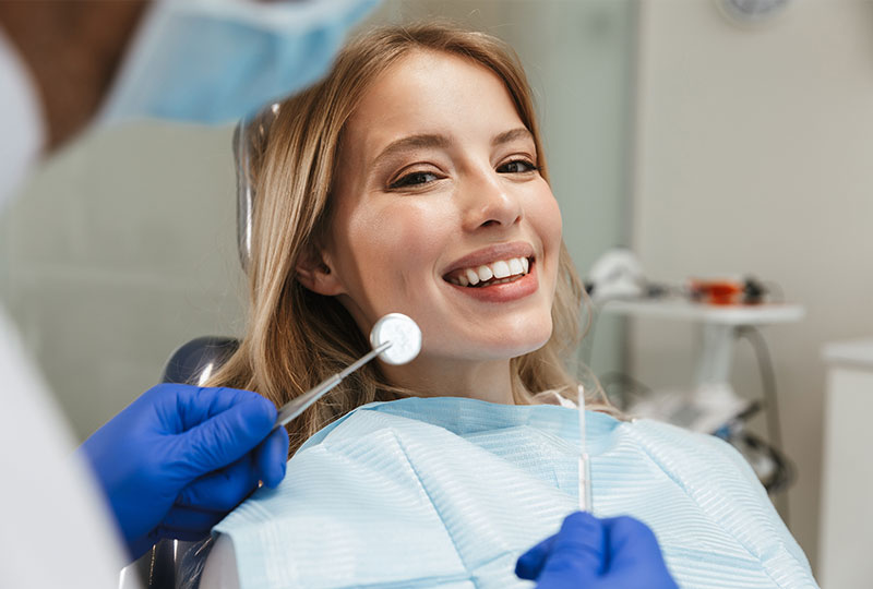 A group of five individuals, possibly dental professionals, in a dental office setting, celebrating with raised hands and thumbs up.