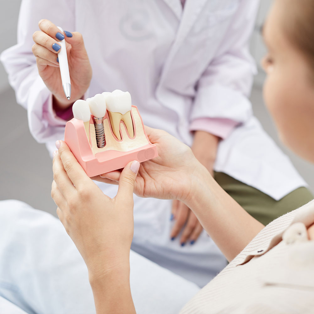 A person is holding up a small, clear plastic tray with a single toothbrush-shaped object inside it.