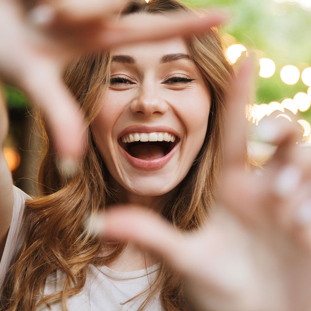 A dental professional is assisting a patient with a digital display of the patient s mouth, highlighting dental work in progress.